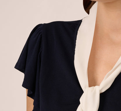 Flutter Sleeve Tie Neck Knit Top In Navy Ivory